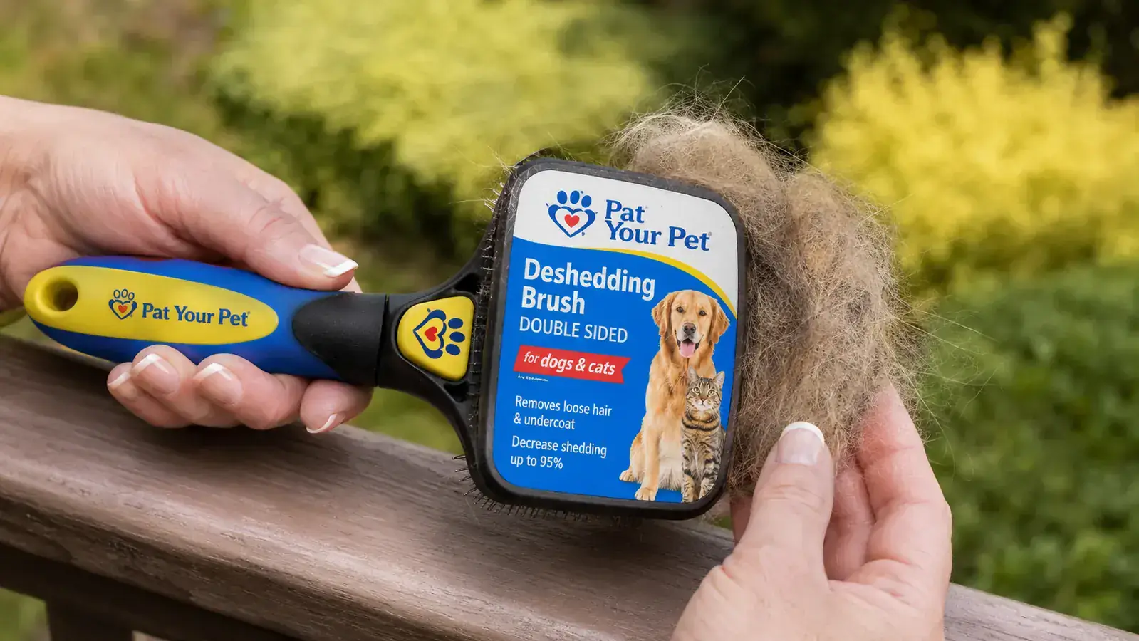 Hand holding a deshedding brush loaded with German Shepherd undercoat fur after a single grooming session